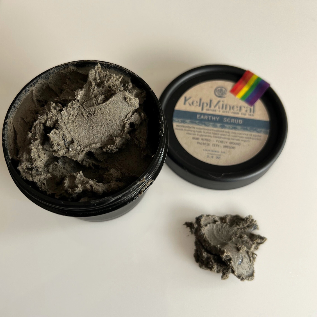 product container is open to show what the grounding scrub  looks like.  There is a thick smear of scrub on a white counter.  The scrub is gray, smooth like clay, with  texture